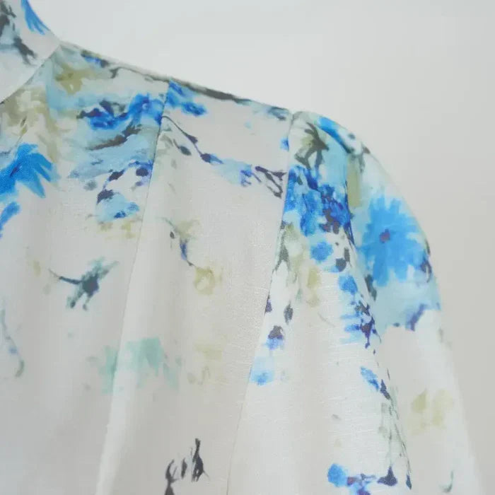 Amelia – Elegancia atemporal en floral azul con cuello alto